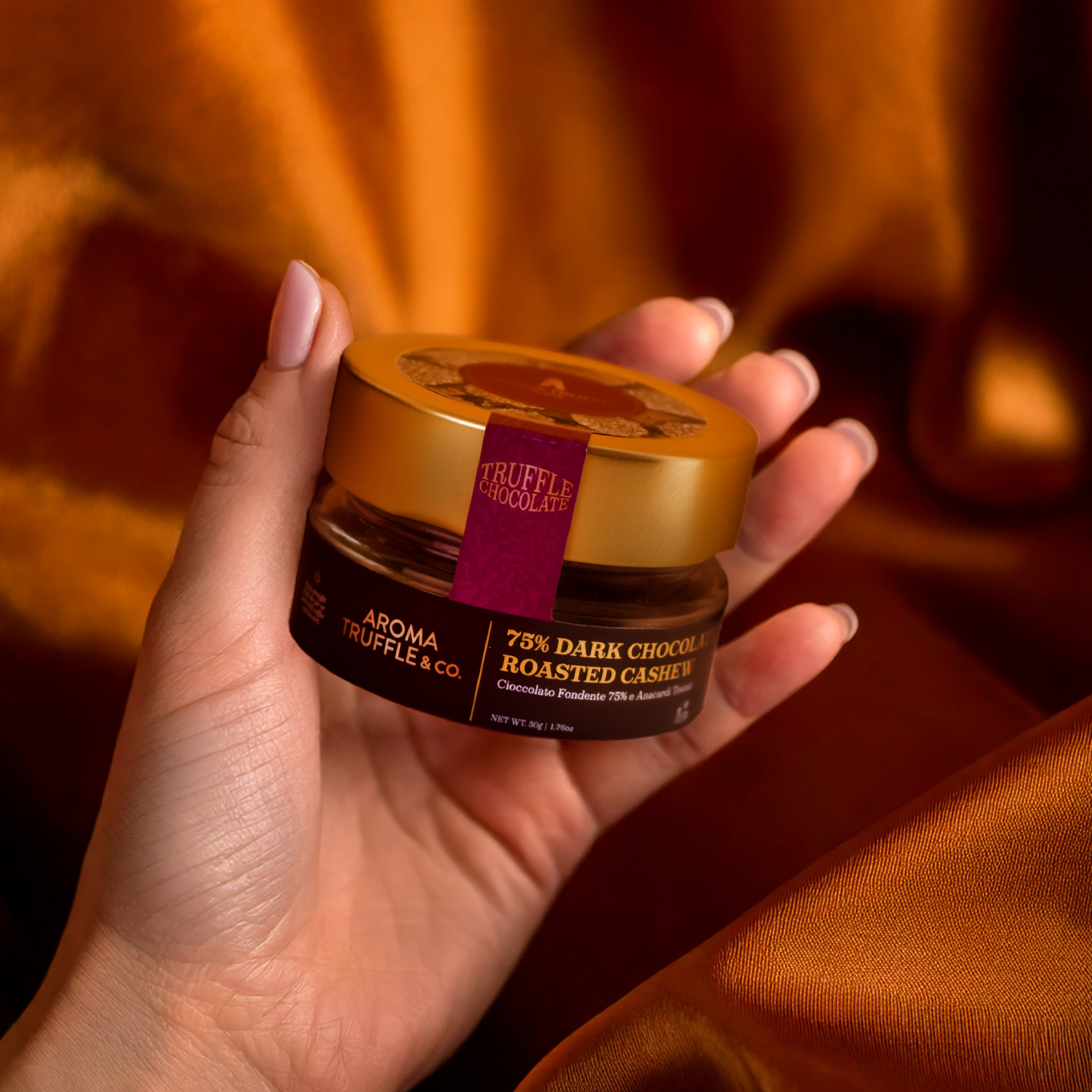 Hand holding a jar of dark chocolate roasted cashew