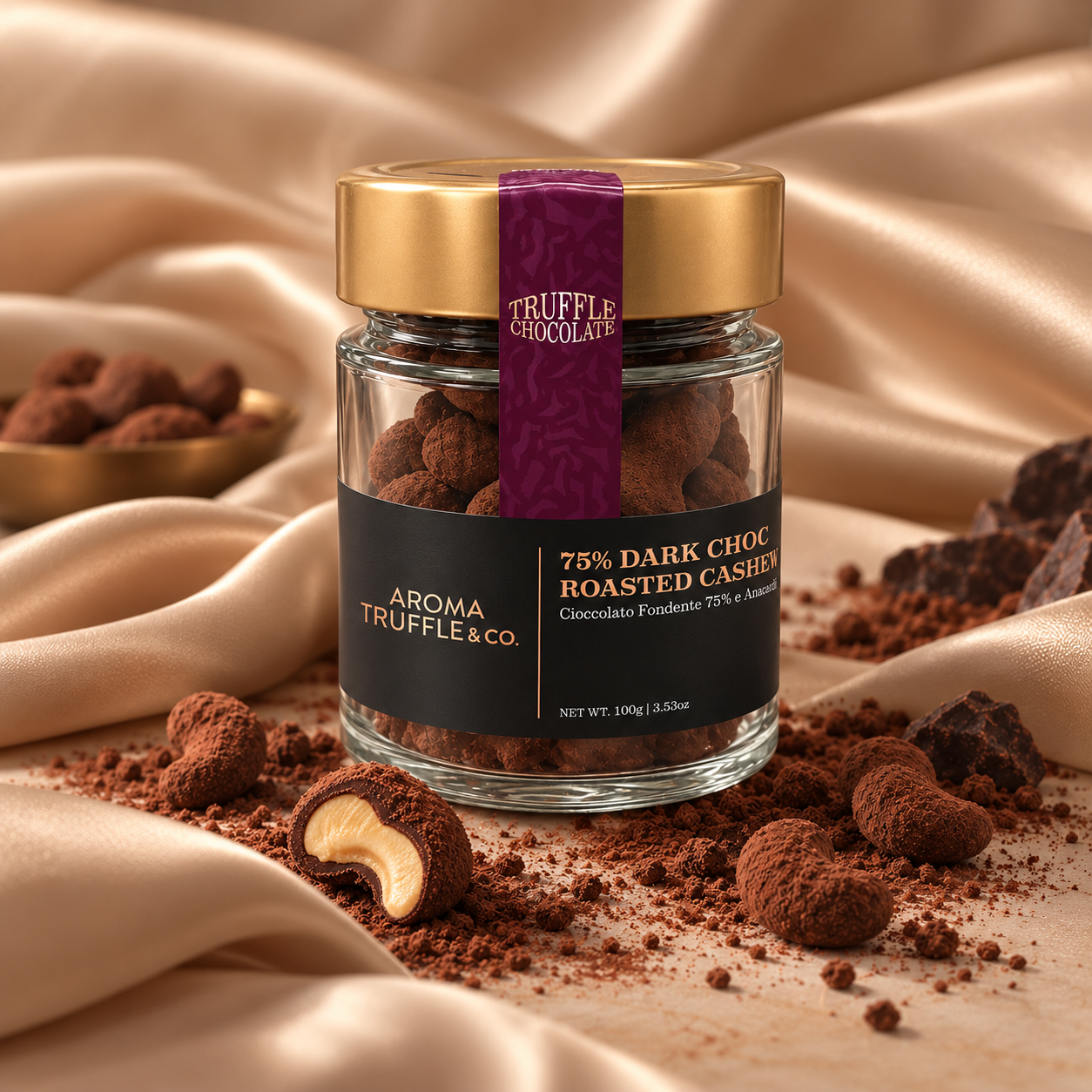 A glass jar of 75% Dark Choc Roasted Cashews set on draped champagne silk with scattered cocoa powder and chocolate pieces. 