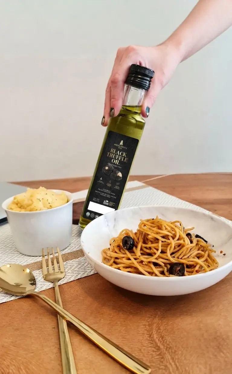 Bowl of pasta with a bottle of Black Truffle Oil 500ml on a wooden table